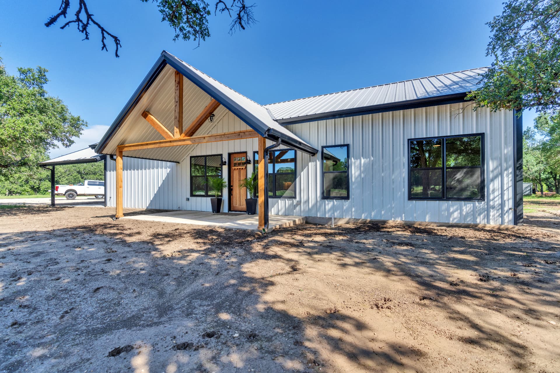 Front elevation of the Brinley Barndominium under live oaks